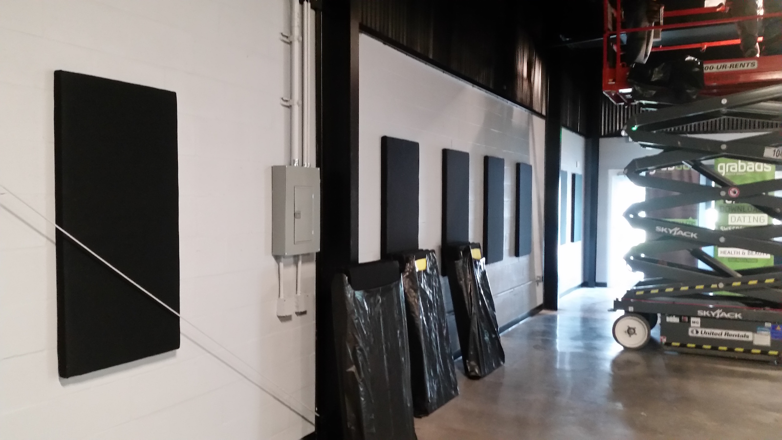 Distributed acoustic ceiling panel array across creative agency workspace