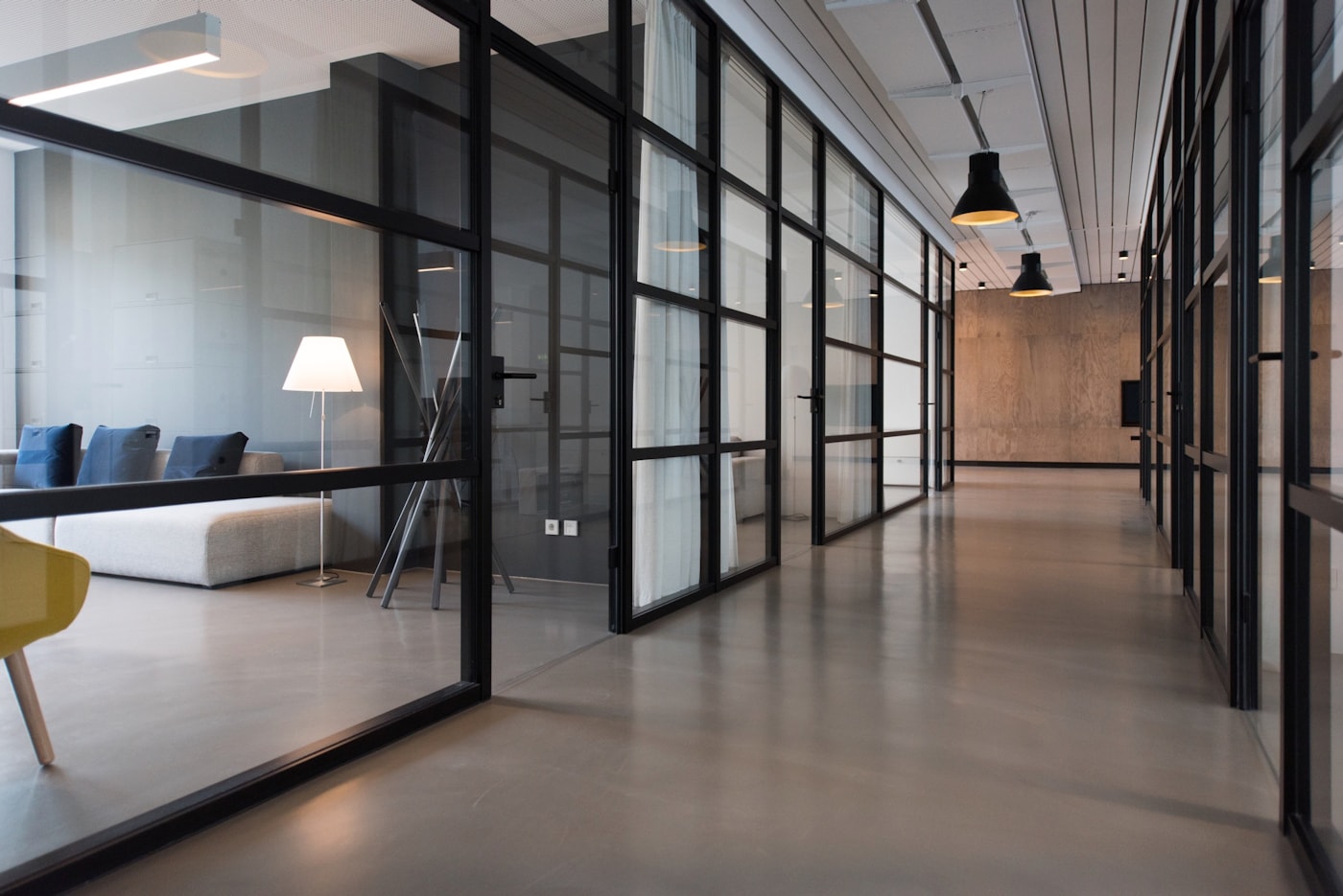 Modern glass-walled office corridor representing the architectural and corporate environments where acoustic consulting matters most